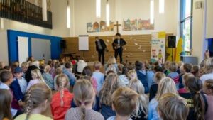 Viele Kinder in der Aula der Schule in Stralsund, beim Schulgottesdienst.